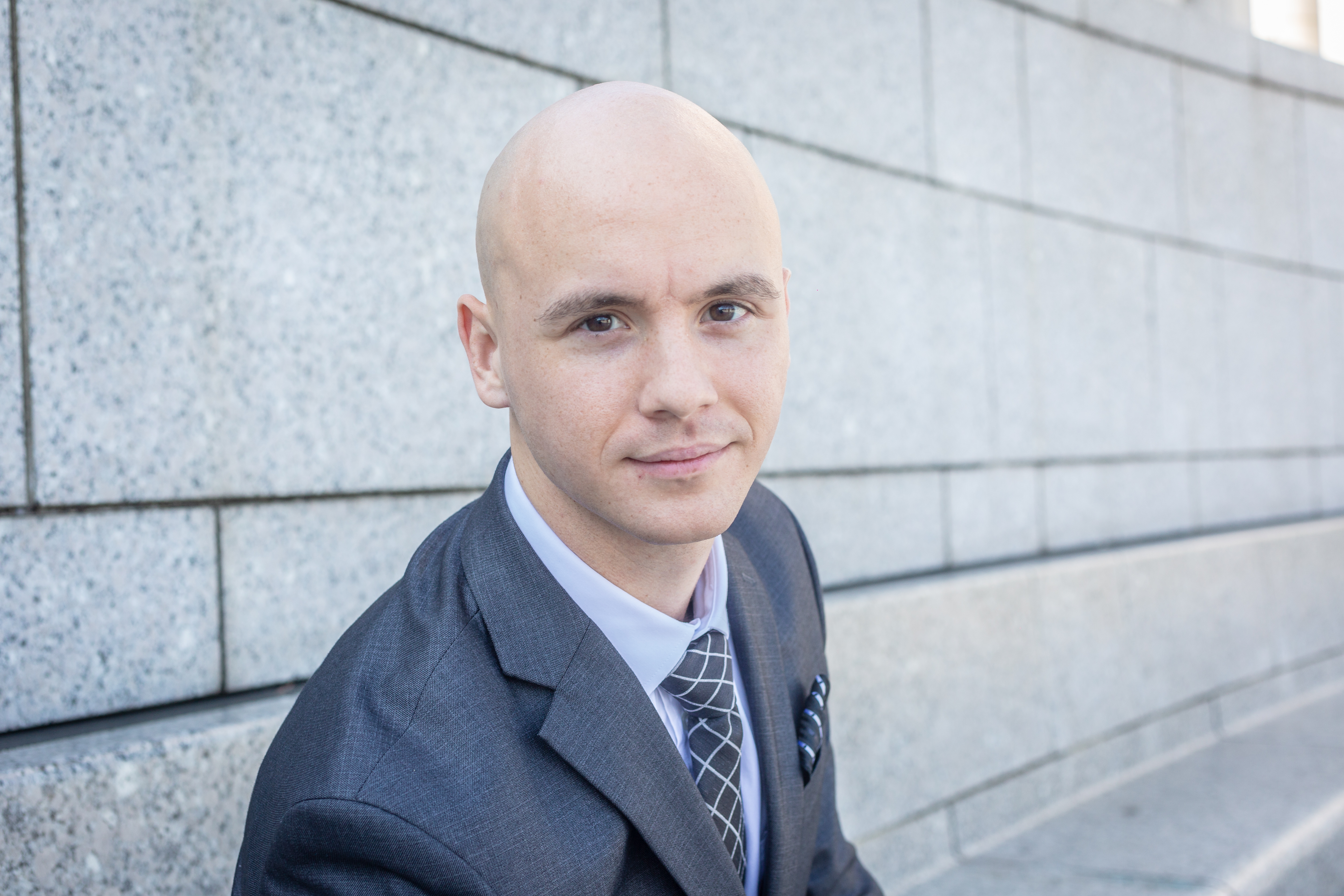 Professional headshot of Spencer Turkal, co-founder of Sierra Hotel Financial, wearing a suit and sitting outdoors in the WW2 memorial.