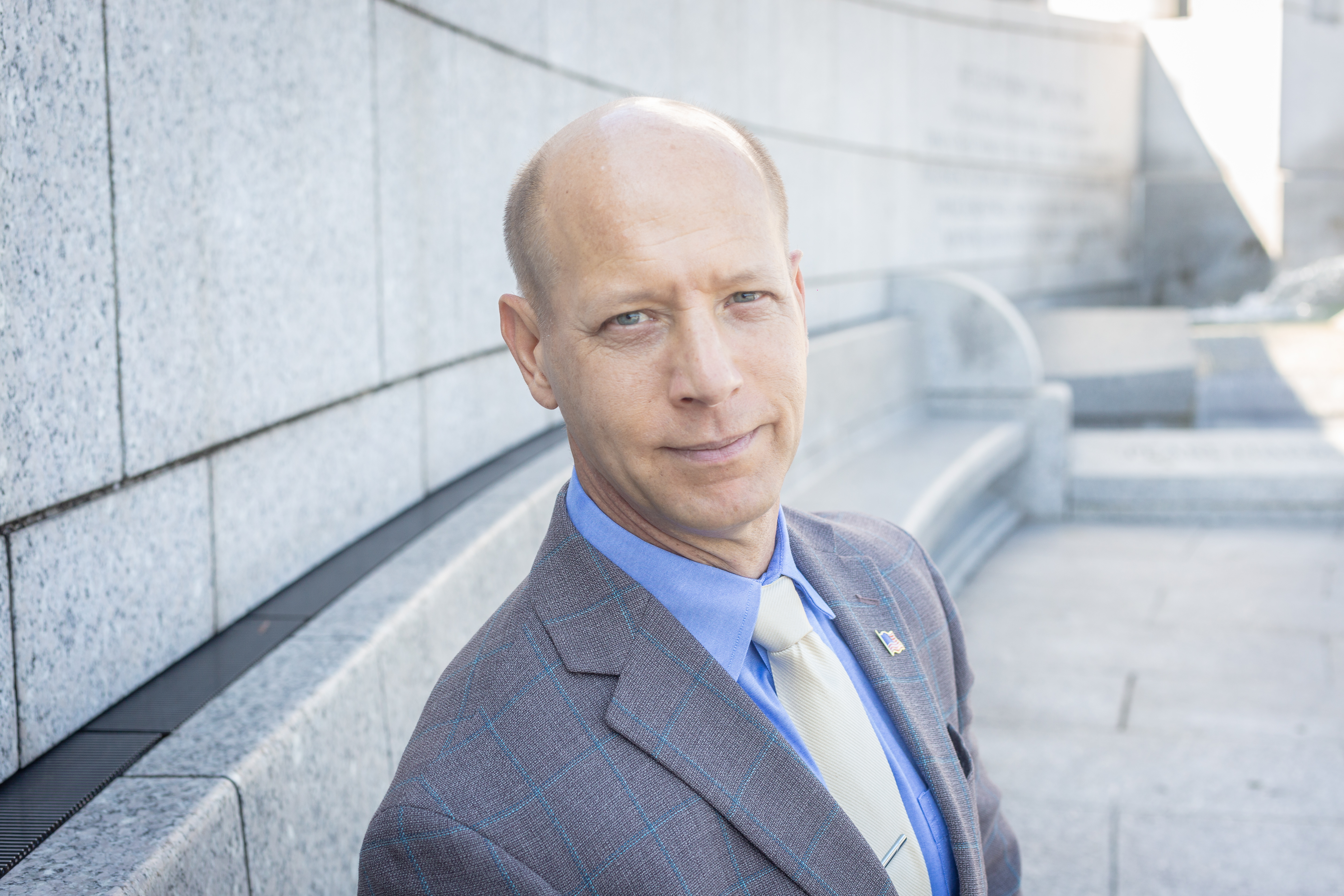 Professional headshot of Joe Turkal, co-founder of Sierra Hotel Financial, wearing a suit and sitting outdoors in the WW2 memorial.